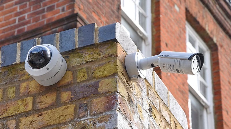 image of two CCTV cameras mounted on an external brick wall of a commercial property
